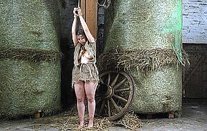 Filthy fat woman with bare feet is kept in a barn with chain shackles